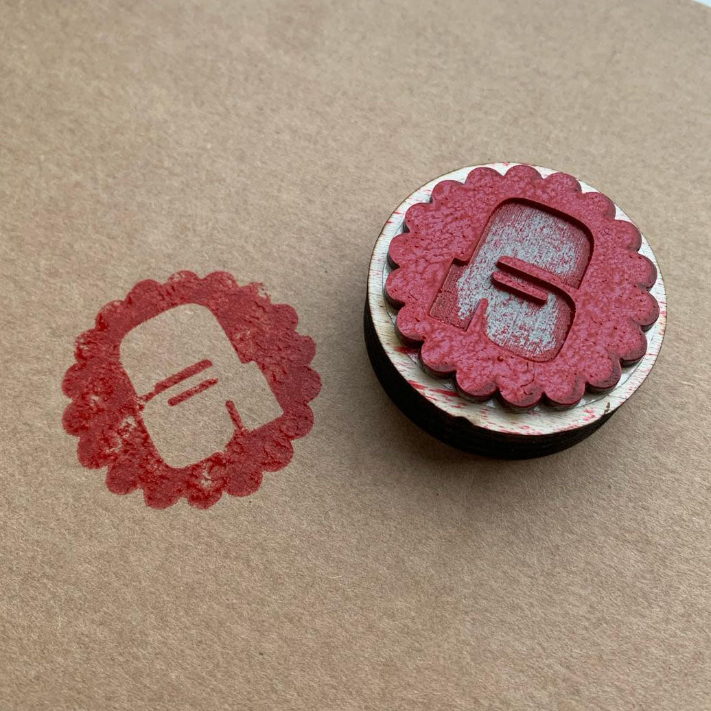 Voorbeeld van een laser cut stempel letter A in rode inkt